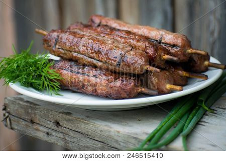 Lulya Kebab From Meat On A White Plate And Wooden Board