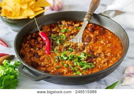 Mexican And American Food Chili Con Carne Served With Nachos, Pepper And Herbs. Selective Focus.