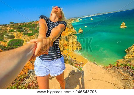 Follow Me, Woman Holding Hand At Above Promontory Of Praia Do Camilo In Algarve, Portugal, Europe. W