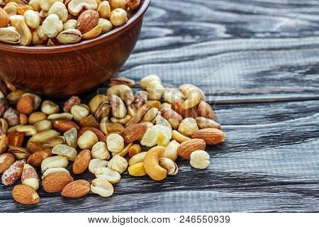 Mix Nuts In Earthenware On A Wooden Background.