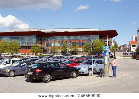 Lulea, Sweden - June 20, 2018: A Woman Buys A Parking Ticket In A Vending Machine At The Car Park In