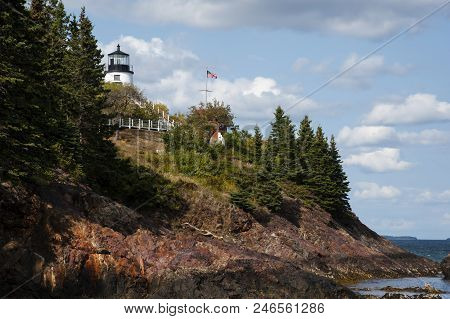 Olws Head Lighthouse Sits Atop Rocky Cliffs Overlooking Rockland Harbor On A Summer Day In Maine.