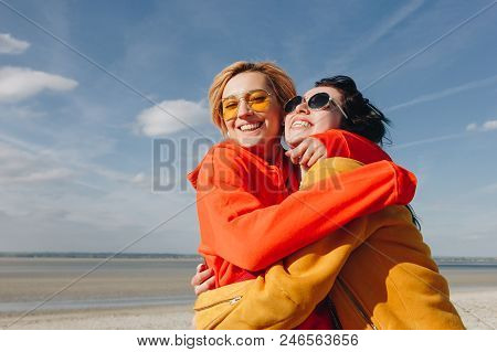 Smiling Female Friends Embracing On Sandy Beach, Saint Michaels Mount, Normandy, France