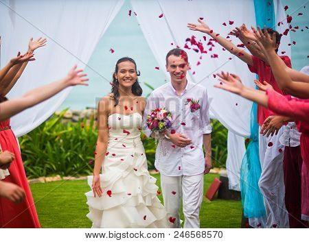 The Bride And Groom After The Wedding Ceremony. Guests Showered The Newlyweds With Rose Petals On Th