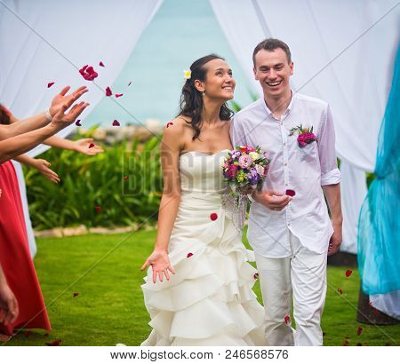 The Bride And Groom After The Wedding Ceremony. Guests Showered The Newlyweds With Rose Petals On Th