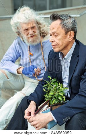 Sad And Inspired. Pessimistic Extremely Sad Man Feeling Apathetic While Sitting Near Inspired Elderl