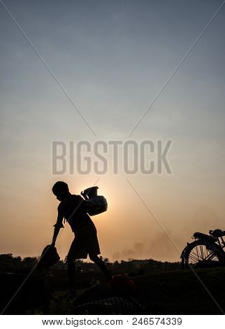 Mrauk U Myanmar On March 20, 2016: Silhouette Of Boy Fetching Water