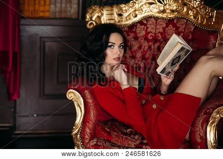 Portrait Of Hot Haired Girl In Short Red Dress With Deep Decolte, Seductive Touching Her Lips By Fin