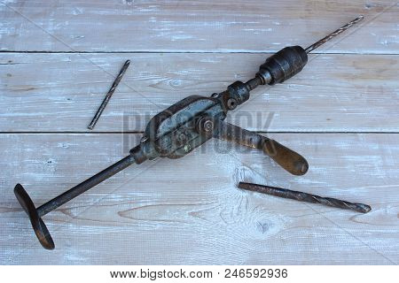 Old Hand Drill Against The Background Of Boards