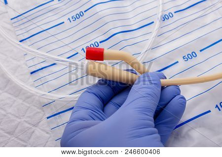 Nurse Inflates Urinary Catheter Bulb With Leg Drainage Bag On Sterile Field
