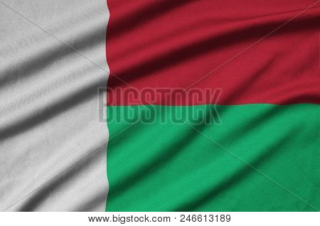 Madagascar Flag  Is Depicted On A Sports Cloth Fabric With Many Folds. Sport Team Waving Banner