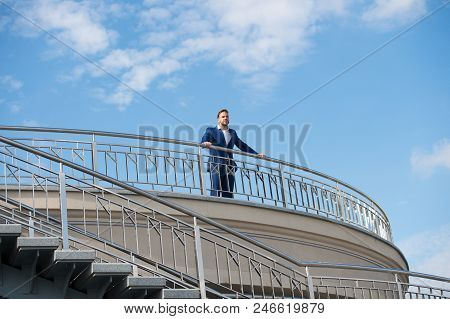 Confident Businessman Stand On Balcony On Cloudy Blue Sky. Man In Formal Wear Outdoor. Looking To Th