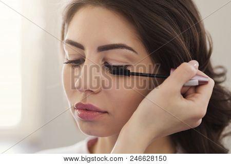 Make-up Artist Makes Up Eyelashes For Beautiful Girl In The Beauty Salon, Closeup