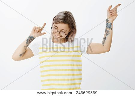 Dance And Enjoy Life. Portrait Of Positive Happy Young Girlfriend In Striped Tellow T-shirt, Waving 