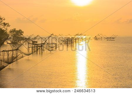 golden sky above fishing trap in Pak Pra Talay Noi sea Phatthalung south of Thailand
