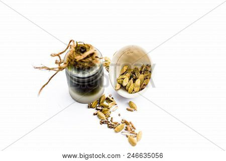 Green Colored Dry Fruit Essence Of Green Cardamom Or Elaichi Isolated On White In Transparent Bottle