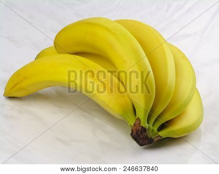 Yellow Bunch Of Bananas On A Light Marble Background Close-up