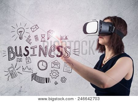 Woman In Vr Headset Against A Concrete Wall Background Touching A Virtual Business Sketch