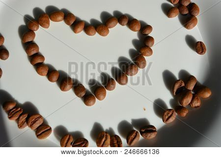 On A White Glass Plate Lie Brown Coffee Beans Laid Out In The Form Of A Heart Of Coffee Beans Love