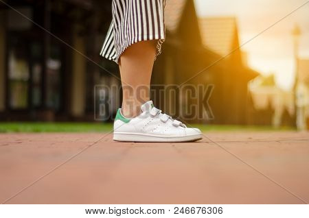 Female Legs In Street Sneakers Nature Sun Skyon Blur Background Beauty Fashion
