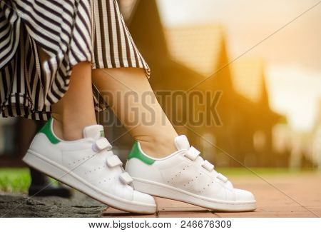 Female Legs In Street Sneakers Nature Sun Skyon Blur Background Beauty Fashion