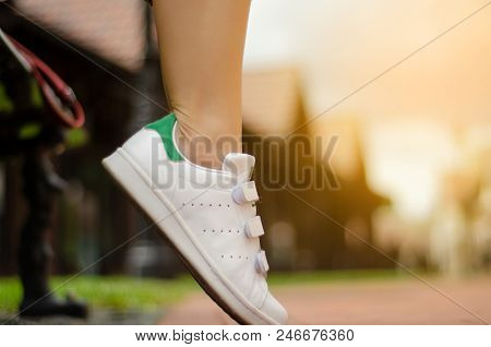 Female Legs In Street Sneakers Nature Sun Skyon Blur Background Beauty Fashion