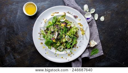 Healthy Lettuce Arugula Salad With Edible Flowers And Microgreens On White Plate, Dark Background. T