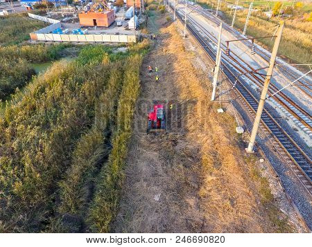 The Bulldozer Clears The Space Along The Railway Tracks. Raking Of Reeds By Bulldozer.