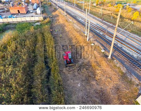 The Bulldozer Clears The Space Along The Railway Tracks. Raking Of Reeds By Bulldozer.