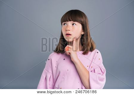 Influx Of Thoughts. Cute Teenage Girl With Freckles Pondering Over Something And Touching Her Cheek 