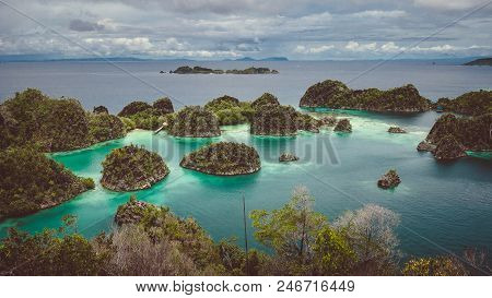 Panorama Of Pianemo Island Overgrown With Jungle Plants, Surrounded By Shallow Turquoise Colored Oce