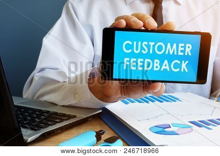 Busnessman Holding Phone With Words Customer Feedback.