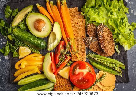 Vegetarian Different Snacks And Fresh Vegetables On A Dark Background. Healthy Vegan Food Concept.