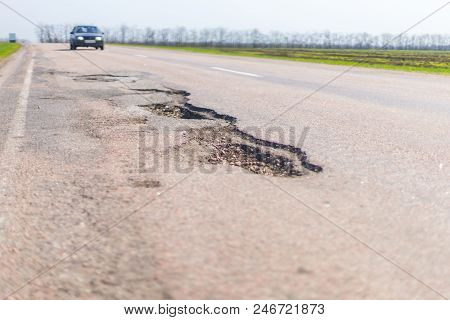 Large Deep Pothole An Example Of Poor Road Maintenance Due To Reducing Local Council Repair Budgets