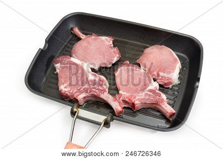 Pork Loin Chops With Partly Frenched Ribs On The Grill Pan During Cooking On A White Background
