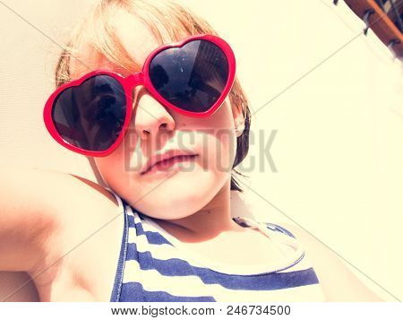 Closeup of young caucasian girl sunbathing with sunglassses