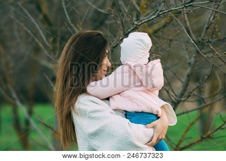 Mother With Her Daughter Playing On The Beach. Mother Hugging Her Daughter.
