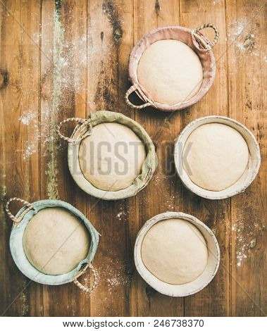 Sourdough For Baking Homemade Wheat Flour Bread In Baskets, Over Rustic Wooden Kitchen Table Backgro