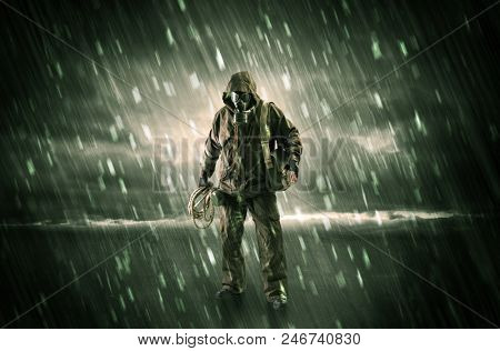 Terrorist in a stormy space with gas mask on his hand and weapons on his arm