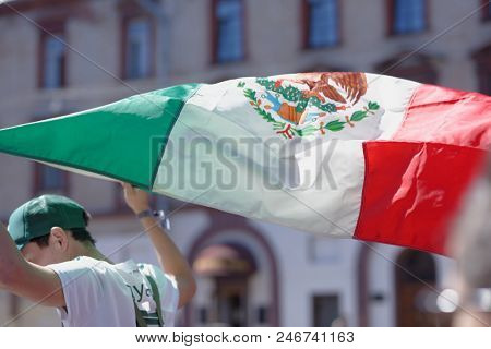 ST. PETERSBURG, RUSSIA - JUNE 20, 2018: Mexican football fan with national flag at FIFA Fan Fest in Saint Petersburg during FIFA World Cup Russia 2018. The city host 7 matches of FIFA World Cup