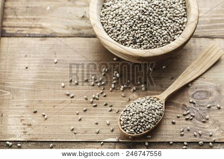 Cannabis Seeds In A Plate And Spoon On A Wooden Background, Space For Text