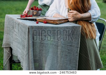 Memories Of The Elderly. Visit Grandmother. Grandmother With Her Grandchildren Sitting In A Chair In