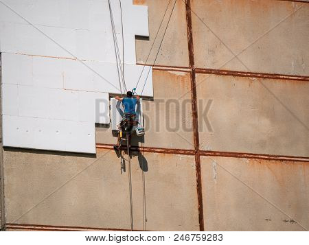 Insulation And Energy Saving Technology Concept. Worker Making Building With Heat Insulated Facade.