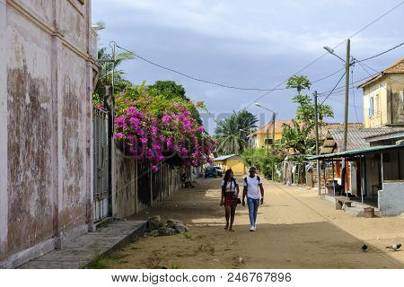 Grand Bassam, Cote Divoire - April 9 2018: Young Couple Stroll Through Bougainvillea Lined Street In