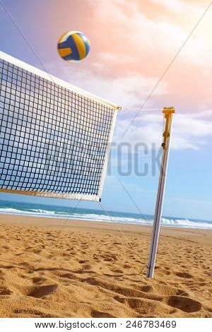 Bright beach scene with a net and volley ball at sunset
