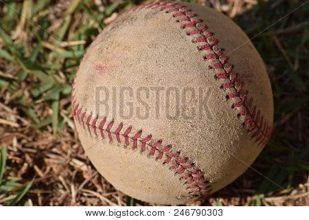 Nostalgic Baseball In The Grass On A Baseball Field