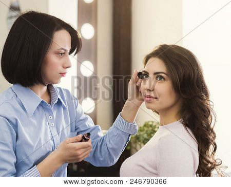 Make-up Artist Makes Up Eyelashes For Beautiful Girl In The Beauty Salon