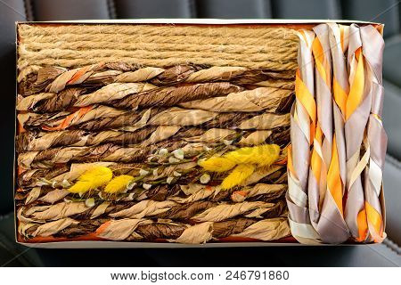Holiday Decor Concept. Handmade Gift Box Wrapped With Simple Brown Paper And Decorated With Ropes On