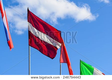The Main Latvia Flag Waving On The Sky Blue Background