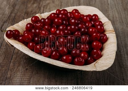 Fresh Red Cherries In A Wooden Plate On A Wooden Table. Wooden Plate On A Wooden Background. A Plate